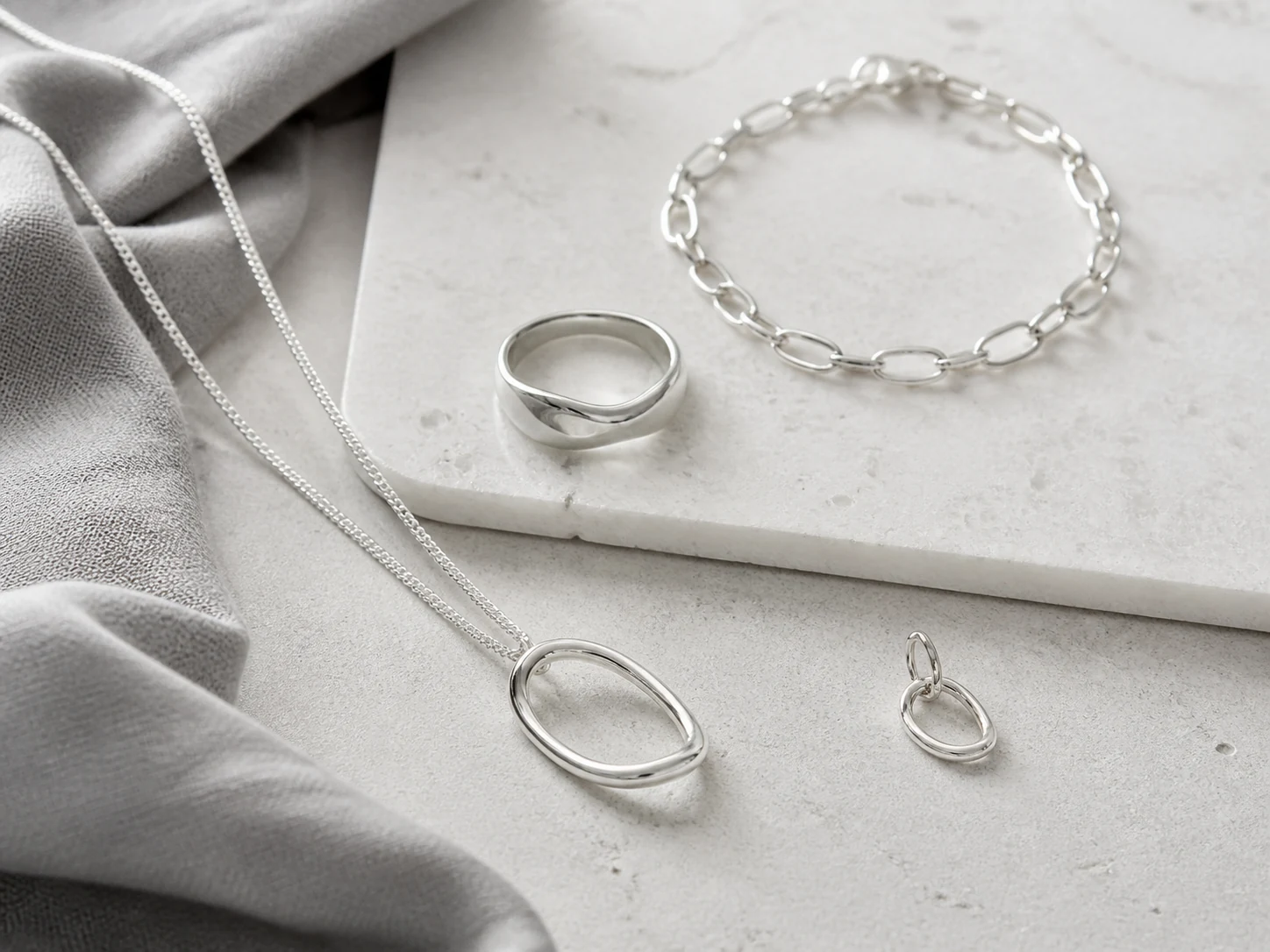 A curated group of minimal silver jewellery pieces